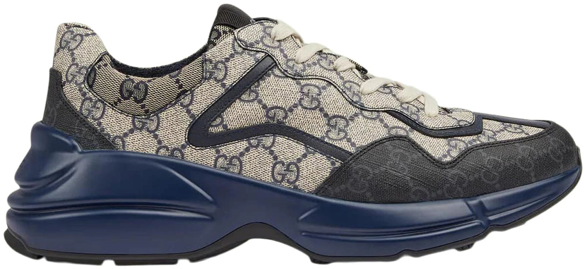https://images.stockx.com/images/Gucci-Rython-GG-Grey-Navy.jpg?fit=fill&bg=FFFFFF&w=1000&fm=webp&auto=compress&q=90&dpr=2&trim=color&updated_at=1649259866